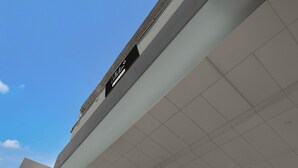 A modern building with a flat roof and a sign that reads 'Café'. - Super Collection O Sector 18 Metro Station (Noida)