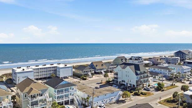A coastal residential area with beachfront properties, including multi-story buildings with balconies and a beach in the background. - Paws & Palms-Pet Friendly-Pool-Free Parking (North Myrtle Beach)