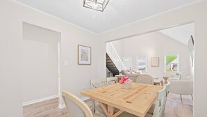 A dining area with a wooden table, chairs, and a staircase leading to another level. - Newly Renovated VB Retreat Comfort Space Home (Virginia Beach)