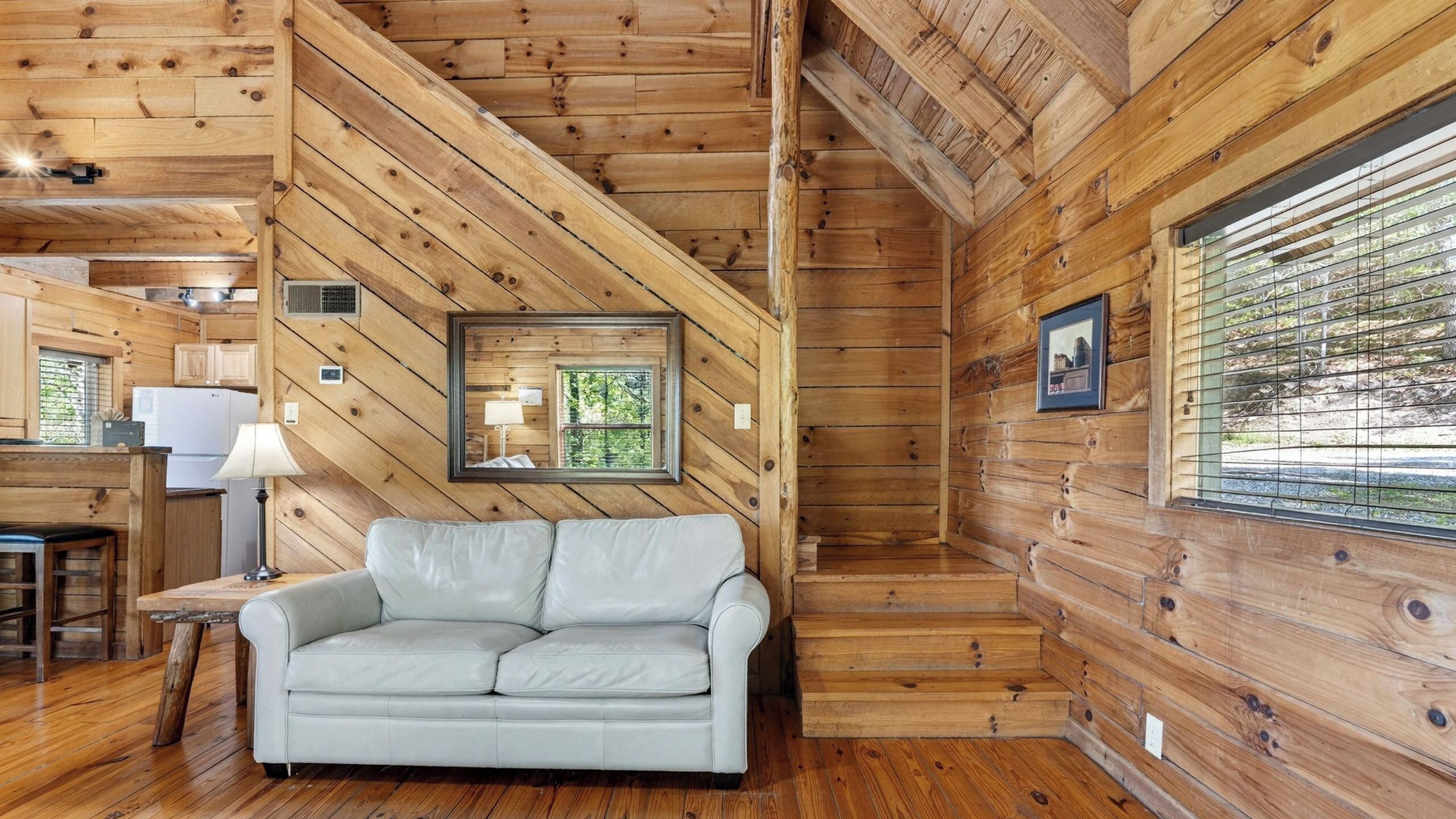 L’intérieur d’une cabine comprenant un canapé, un coin repas, une cuisine et un escalier.