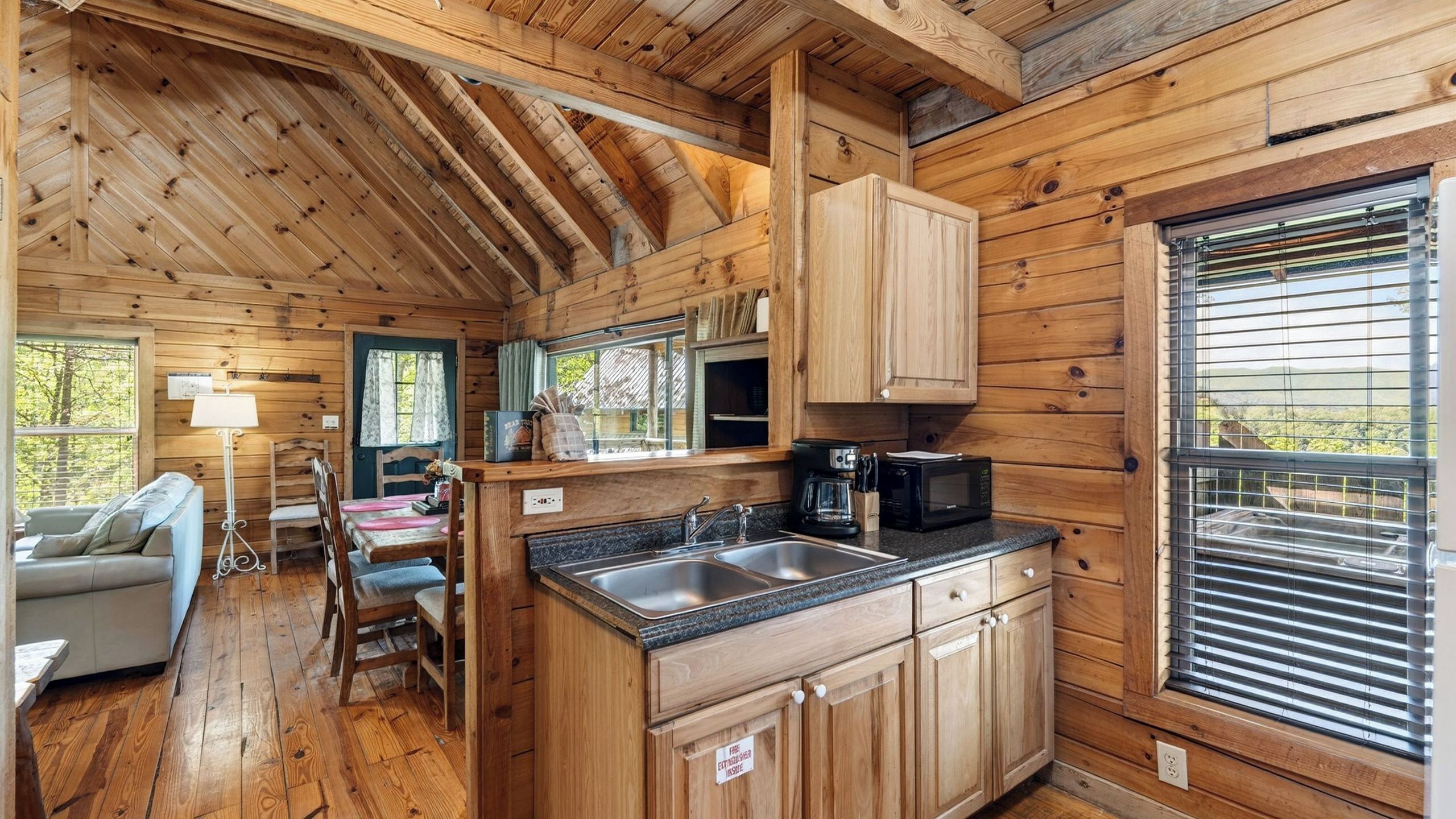 A cabin interior with a kitchen, dining area, and a sofa.