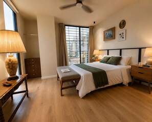 A hotel room with a bed, bedside tables, a bench, a window with curtains, a ceiling fan, and artwork on the wall. - Suite vintage · rooftop bar · Country Club GDL · limpieza diaria (guadalajara)
