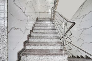 Eine Marmortreppe mit Metallgeländern, die zu einer oberen Etage führt.