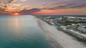 A coastal cityscape with a beach, buildings, and a sunset. - Blue Moon by Avantstay Beach-front Home + Pool + Private Boardwalk + Outdoor Lounge Walk to Lake Powell (Panama City Beach)