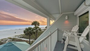 A balcony with white railings, a view of the beach, and a palm tree. - Blue Moon by Avantstay Beach-front Home + Pool + Private Boardwalk + Outdoor Lounge Walk to Lake Powell (Panama City Beach)