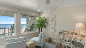 A room with a view of the beach, a chair, a desk, a lamp, and a decorative wall piece. - Blue Moon by Avantstay Beach-front Home + Pool + Private Boardwalk + Outdoor Lounge Walk to Lake Powell (Panama City Beach)