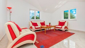 Een moderne woonkamer met twee banken, een bijzettafeltje en een rood vloerkleed.