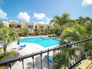 A hotel with a swimming pool, palm trees, and a clear blue sky. - Garden Condos APT 3 Affordable 1BR APT in Sosua (Sosúa)