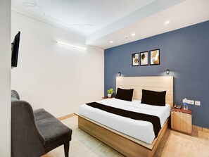 Een moderne hotelkamer met een bed, bureau en stoel.