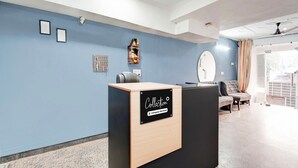 A reception desk with a sign reading 'Collection,' a wall-mounted key holder, and a small shelf with decorative items. - Super Collection O Sector 20 Noida (Noida)