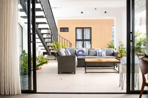 A modern living room with a sofa, coffee table, and staircase. - 2BR with JacuzziRooftop & Golf View (Punta Cana)