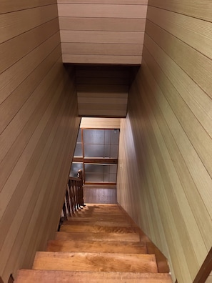 A wooden staircase with a view of a room at the top.