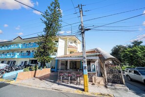 A building with a bar area, outdoor seating, and a covered entrance. - Centric Studio in Sosua Center Pool & Workspace (Sosúa)