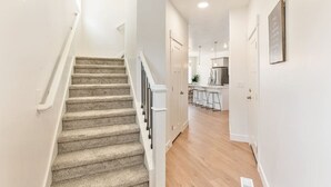 Eine Treppe führt zu einem Küchenbereich mit einer Bar und Barhocker.