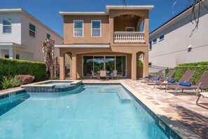 A two-story house with a swimming pool and outdoor seating. - 6BR Reunion Escape w/ Pool, Spa & Outdoor Patio (Kissimmee)