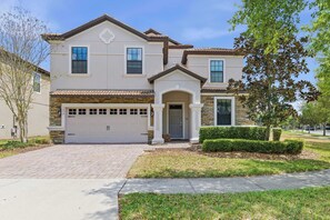 A two-story house with a garage, a front porch, and a well-maintained lawn. - Family retreat w/ pool, hot tub, & resort access (Four Corners)