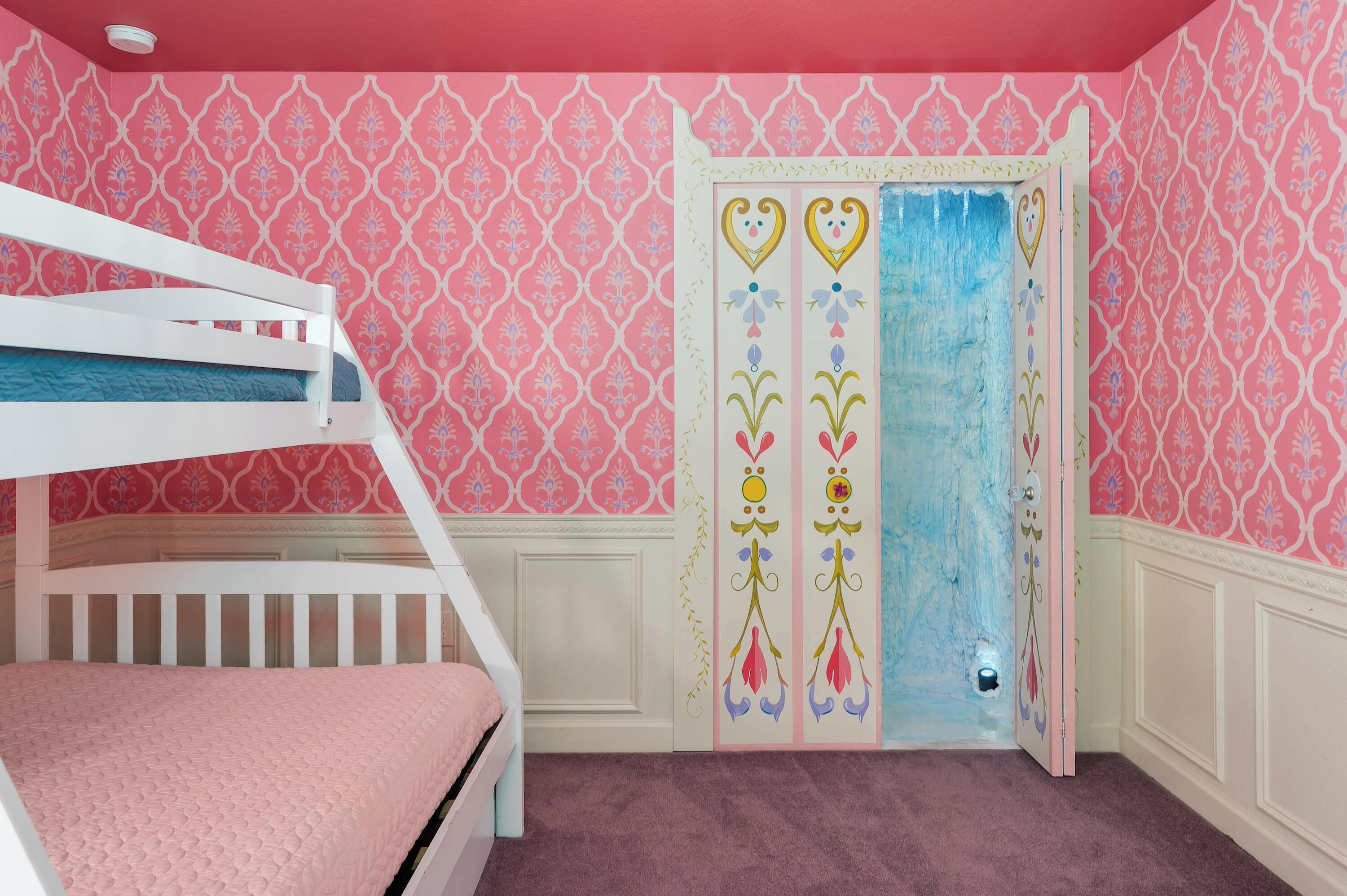 Una habitación con literas, una puerta decorativa y papel tapiz estampado.