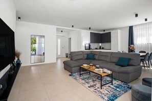 A modern living room with a sectional sofa, a coffee table, and a TV. - Villa Vallis, Labin, Croatia (Labin)