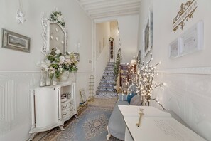A hallway with a white ornate cabinet, a blue patterned rug, and a staircase with blue and white tiles. - Romantic Apartment near Lucca, Lucca, Italy (Lucca)
