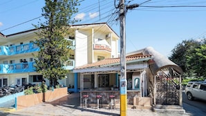 A building with a sign 'EUROPA EUROPA' and a covered outdoor seating area with chairs. - Cheap Hotel Room in Sosua Center! (Sosúa)