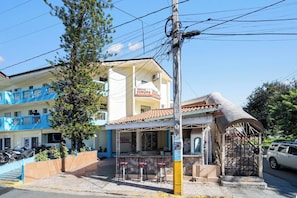 A building with a sign 'EUROPA EUROPA' and a covered outdoor seating area with chairs. - Cheap Hotel Room in Sosua Center! (Sosúa)