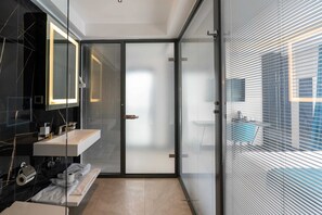 A modern bathroom with a glass door, a white sink, and a mirror. - Gumus Yazar Hotel (Kaş)