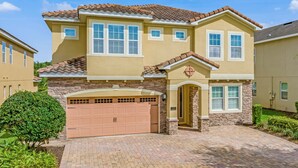 A two-story house with a garage, a well-maintained lawn, and a clear sky. - Outdoor TV, Air Hockey, Foosball, Epic Game Room, Basketball Arcade, 1GB: Summer Breeze (Kissimmee)