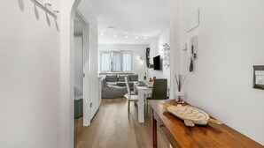 Ein modernes Interieur mit Essbereich, einer Couch und einem Holztisch mit einem dekorativen Gegenstand.
