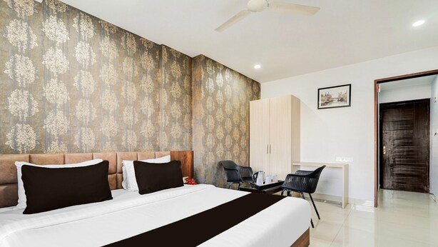 A bedroom with a bed, a desk, and a wardrobe. - Super Townhouse Oak DLF Newtown (Bengaluru)