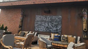 A restaurant named 'Sans Frontières Rooftop Restaurant + Library Bar' with outdoor seating and a chalkboard with writings. - Modern East Legon Studio with Private Balcony - Accra (Accra)
