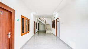 A hallway with a wooden door, a staircase, and a sign indicating room number 02. - Deluxe Hotel Raj Shree (Lucknow)