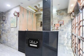 A reception area with a stone wall, a clock, a map, and a sign that reads 'Collection'.