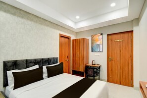 A bedroom with a bed, wooden wardrobe, a desk, and a chair. - Super Deluxe Roommiyapur Metro Station (Hyderabad)