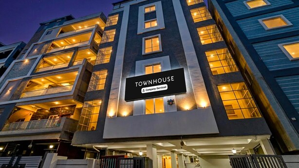 Um edifício de vários andares com uma placa que diz 'TOWNHOUSE'.