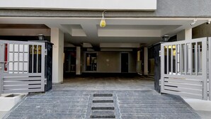 Uma entrada com portão e um lance de escadas que levam a uma área coberta.