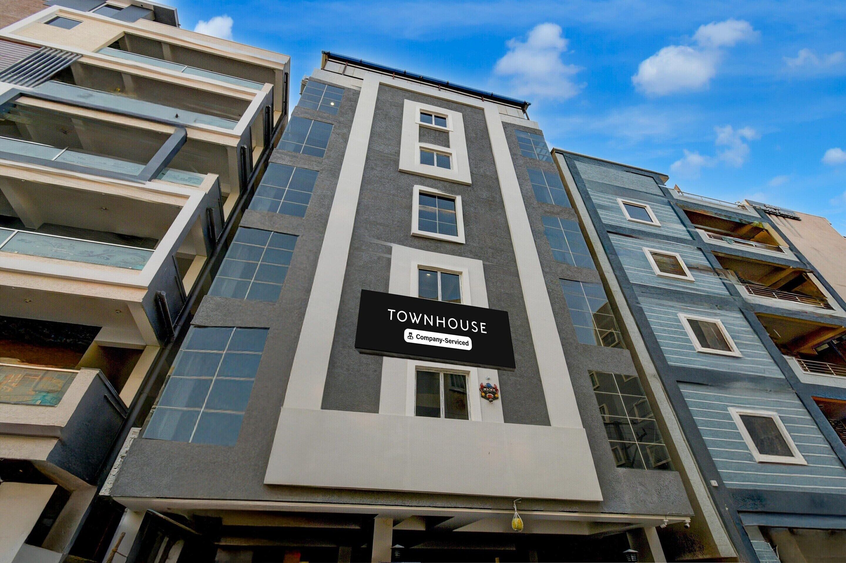 Monikerroksinen rakennus, jonka kyltissä lukee: ”TOWNHOUSE”.