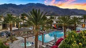 A pool area with palm trees, lounge chairs, and a view of mountains. - "Good Times" at The Vibe - Private Spa, Views (Palm Springs)