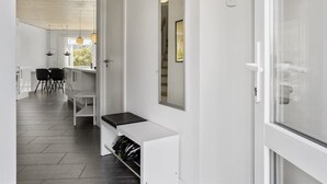 En modern inredning med ett kök, en matplats och en hall som leder till en glasdörr.