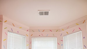 A room with three windows, a pink hand-shaped object, and a white ceiling vent. - Funk-Shui Vibrant Designer Getaway (Atlanta)