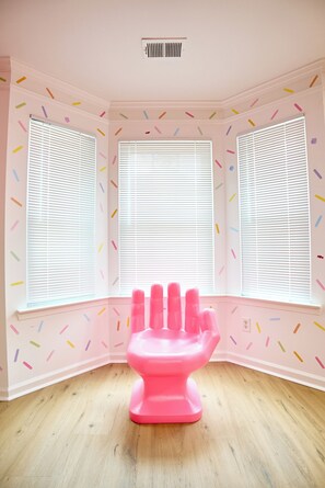 A room with three windows, a pink hand-shaped object, and a white ceiling vent. - Funk-Shui Vibrant Designer Getaway (Atlanta)