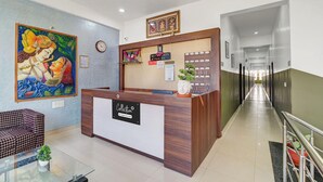 A reception desk with a clock, framed pictures, and a sign for 'RECEPTION Park Inn.' - Super Collection O Chikmangaluru (Chikkamagaluru)