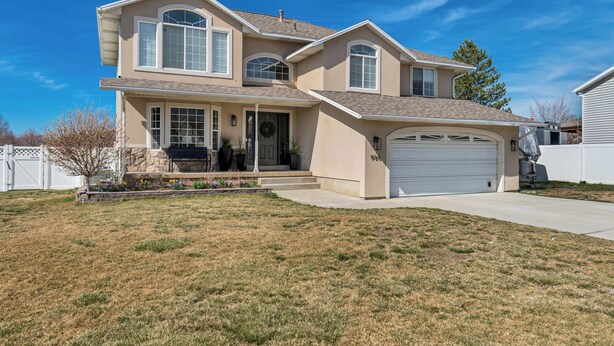 A two-story house with a garage, a front porch, and a landscaped yard.