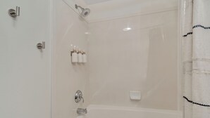 A bathroom with a bathtub, shower, and toilet.