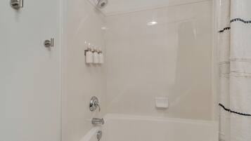 Une salle de bain avec une baignoire, une douche et des toilettes.