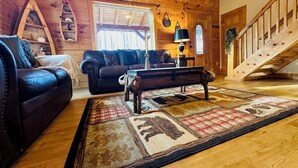 L’intérieur d’un chalet confortable, avec un canapé en cuir, un banc en bois et un tapis à motifs.