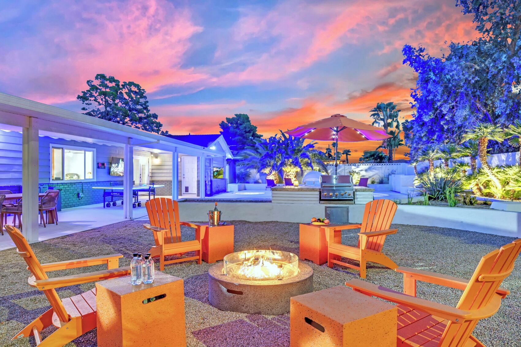 Un espace extérieur aménagé avec un foyer, des chaises et un barbecue.