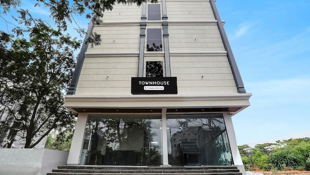 A modern building with a sign reading 'TOWNHOUSE & Company Serviced.' - Premium Townhouse Shamshabad Near Airport (Hyderabad)