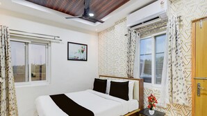 A bedroom with a bed, a bedside table, a window, and a ceiling fan.