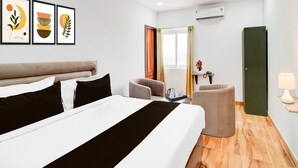 A hotel room with a bed, a chair, a desk, and a green door.