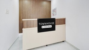 A reception desk with a sign indicating it's a company-serviced townhouse.